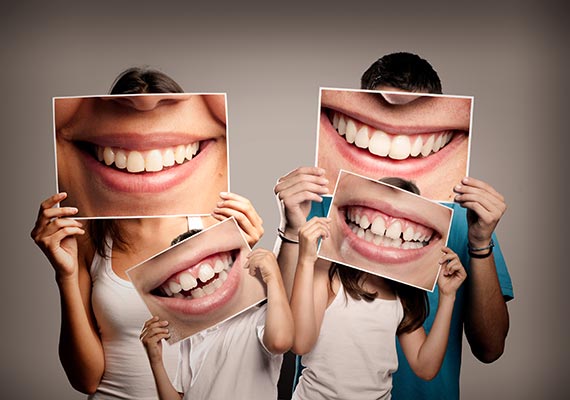 family holding posters of smiles